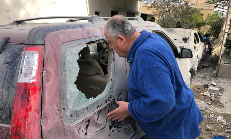 A man checks on the car damaged by the explosion in Benafoul, Lebanon, April 12, 2022. Photo: Xinhua