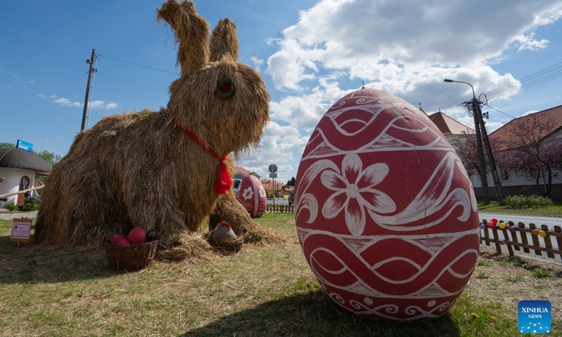 A giant Easter Bunny made of hay is seen among giant painted Easter eggs in the main square of Kethely, Western Hungary, on April 11, 2022.(Photo: Xinhua)