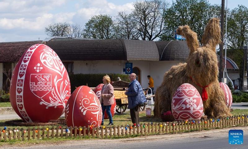A giant Easter Bunny made of hay is seen among giant painted Easter eggs in the main square of Kethely, Western Hungary, on April 11, 2022.(Photo: Xinhua)