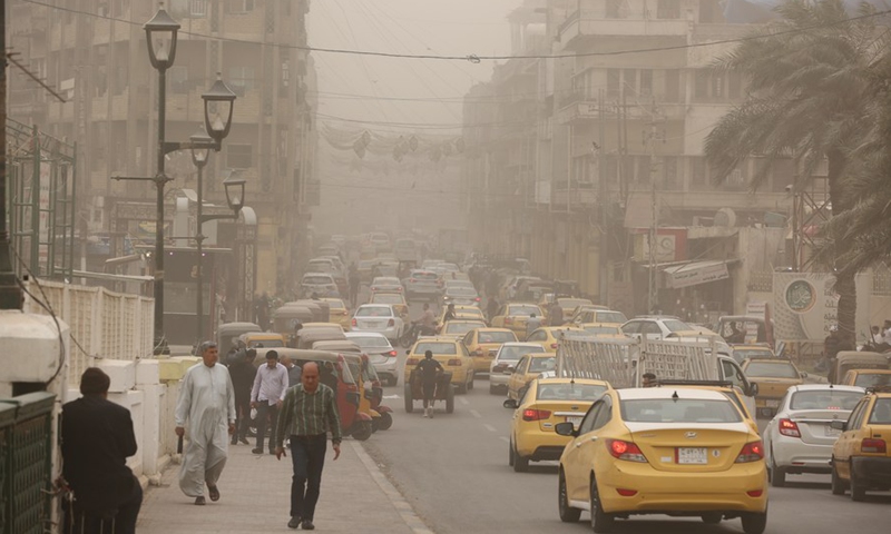 People walk in a dust storm in Baghdad, Iraq, April 12, 2022.(Photo: Xinhua)