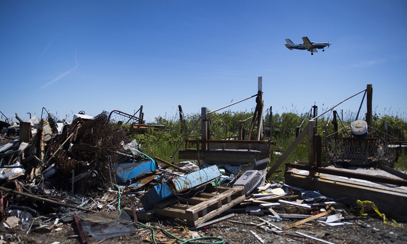 A plane makes it approach to land at the Tangier Airport as it flies over the dump in Tangier, Virginia, the US on May 16, 2017. Photo:AFP