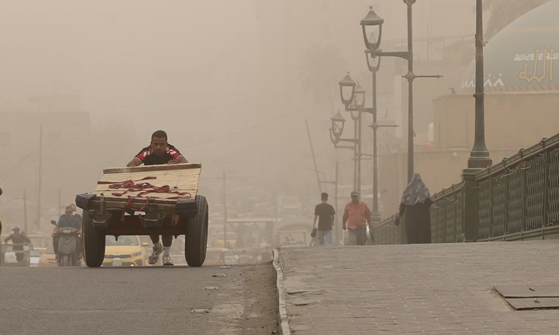 People walk across a bridge during a dust storm in Baghdad, Iraq, April 12, 2022.(Photo: Xinhua)