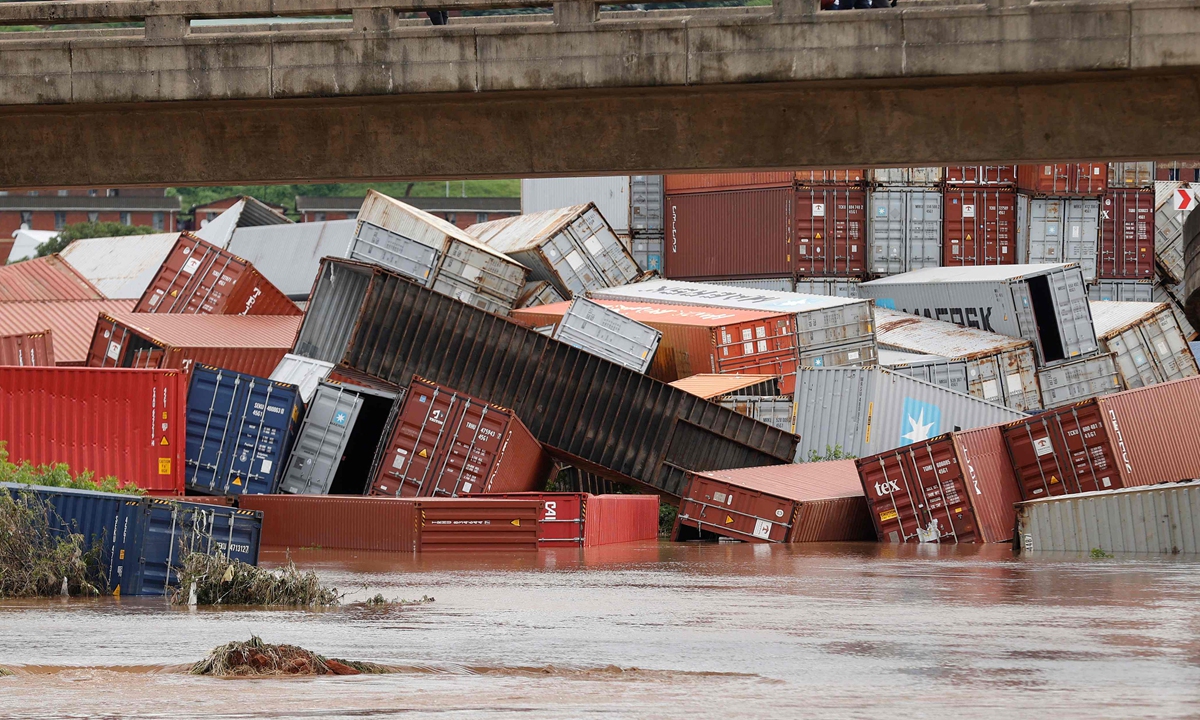 Residents of Umlazi township stand over a bridge and watch containers that fell over at a container storage facility following heavy rains and winds in Durban, on April 12, 2022. At least 45 people were killed after heavy rain in South Africa's eastern coastal province of KwaZulu-Natal, officials said. Photo: Xinhua 