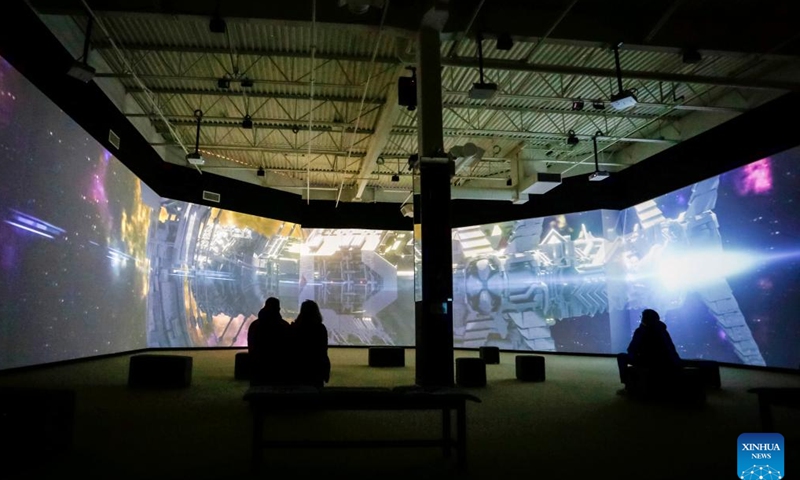 Visitors watch a movie at the Stargazer exhibition in Delta, British Columbia, Canada, on April 13, 2022. The exhibition allows audience to explore the outer space experience through interactive displays, scale replicas of historic rockets, space stations, and satellites.(Photo: Xinhua)