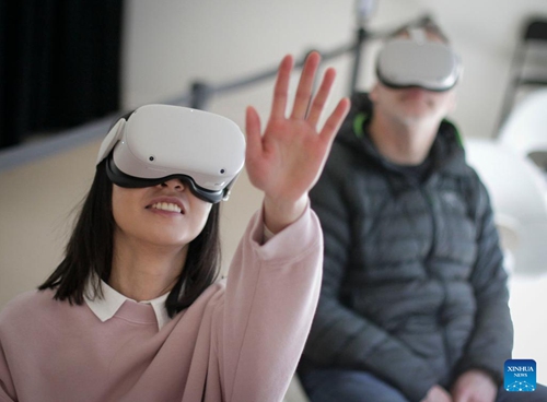 Visitors experience a VR exhibit at the Stargazer exhibition in Delta, British Columbia, Canada, on April 13, 2022. The exhibition allows audience to explore the outer space experience through interactive displays, scale replicas of historic rockets, space stations, and satellites.(Photo: Xinhua)