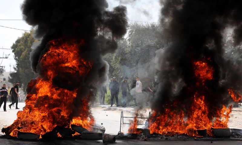 Protesters burn tires during clashes between Palestinian protesters and Israeli forces after Israeli forces stormed the Jenin refugee camp, in the West Bank city of Jenin, April 9, 2022.(Photo: Xinhua)
