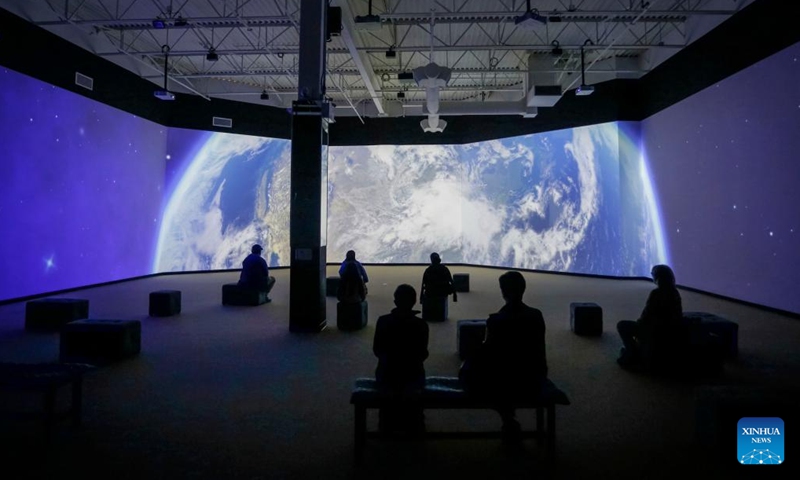 Visitors watch a movie at the Stargazer exhibition in Delta, British Columbia, Canada, on April 13, 2022. The exhibition allows audience to explore the outer space experience through interactive displays, scale replicas of historic rockets, space stations, and satellites.(Photo: Xinhua)