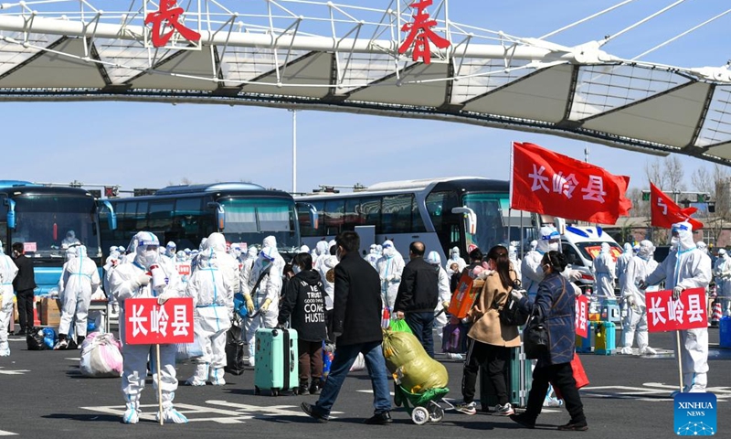 Farmers returning home for spring farming line up to board the chartered buses at a highway exit in Changchun City, northeast China's Jilin Province, April 12, 2022. Northeast China's Jilin Province, a major grain producer now fighting a COVID-19 outbreak, is issuing travel passes for farmers and sending them to farmland in chartered buses. By Sunday evening, around 100,000 farmers had reached their destinations.(Photo: Xinhua)