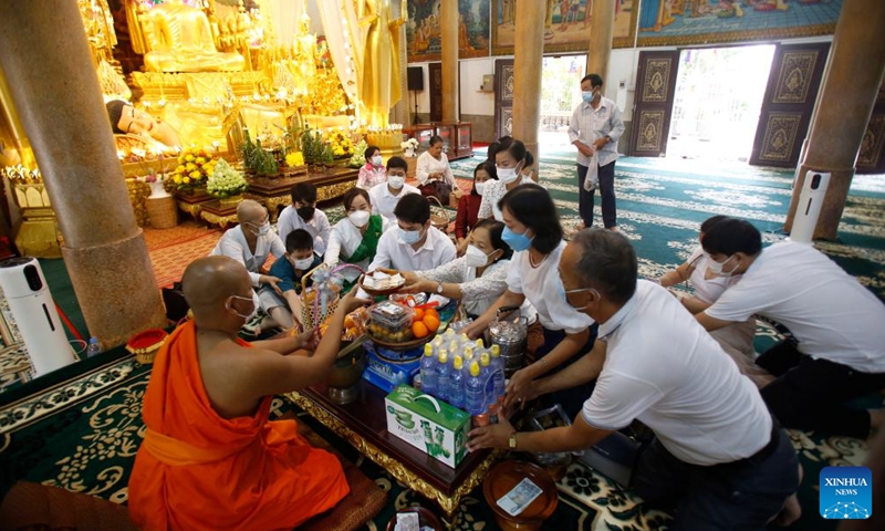 People make offerings to a Buddhist monk at the Langka pagoda in Phnom Penh, Cambodia, April 14, 2022. Cambodia on Thursday began to celebrate the traditional New Year festival after muted celebrations in the last two years due to the COVID-19 pandemic.Photo:Xinhua