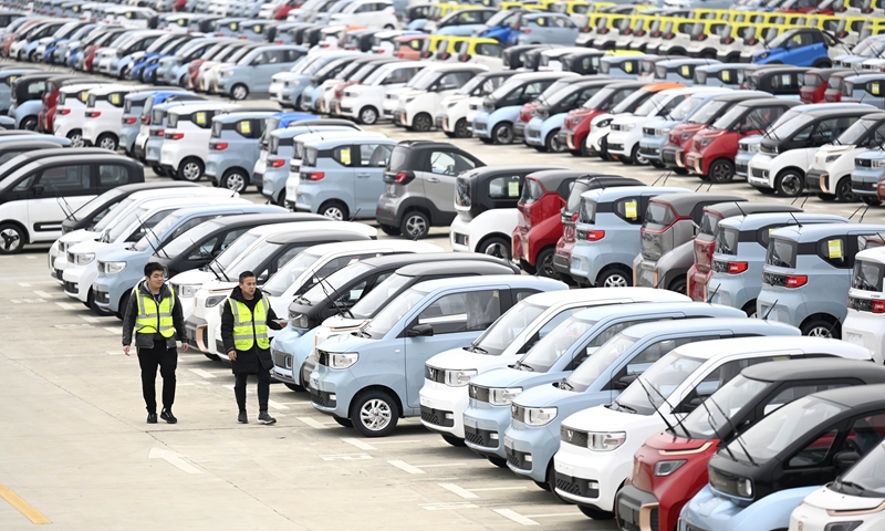 Workers check new energy vehicles at a logistics park in Liuzhou, south China's Guangxi Zhuang Autonomous Region, March 8, 2021. Liuzhou is a famous automobile industrial base. In recent years, local new energy automobile industry has seen vigorous development.Photo:Xinhua

