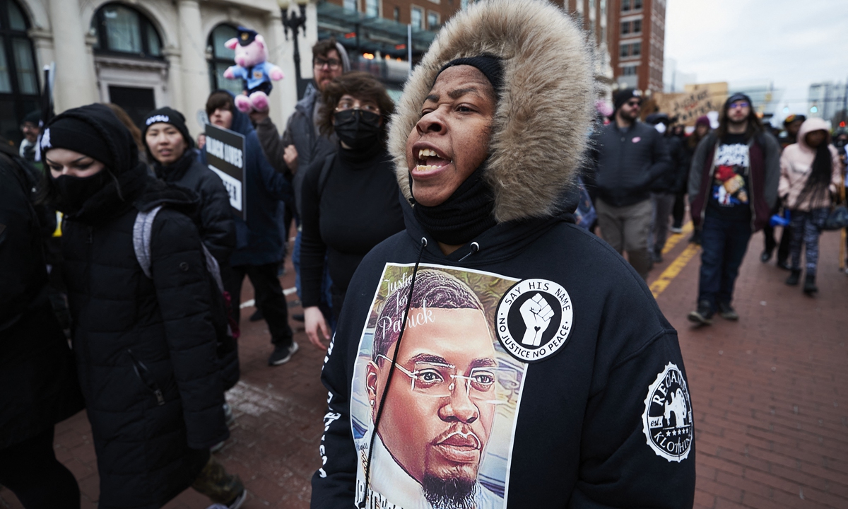 A woman wears a sweater with an image of Patrick Lyoya as protesters march for Lyoya, a black man who was fatally shot by a police officer, in downtown Grand Rapids, Michigan, April 16, 2022. Photo: AFP
