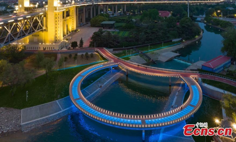 The newly built round glass walkway next to the Nanjing Yangtze River Bridge lights up in Nanjing, east China's Jiangsu Province, April 16, 2022. The colorful round glass walkway looks like a big ring at night. (Photo: China News Service/Yang Bo)