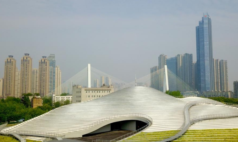 2022年4月18日，中国中部湖北省武汉市月亮湖沿岸引人注目的琴台美术馆鸟瞰图。博物馆建筑面积约43,000平方米，看起来像一个银色露台，将成为新地标在武汉完成后。  （图片：中新社/张畅）