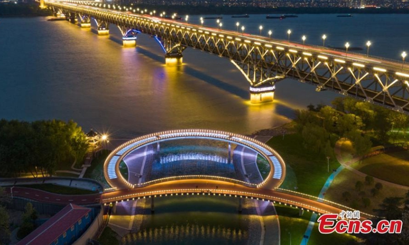 The newly built round glass walkway next to the Nanjing Yangtze River Bridge lights up in Nanjing, east China's Jiangsu Province, April 16, 2022. The colorful round glass walkway looks like a big ring at night. (Photo: China News Service/Yang Bo)
