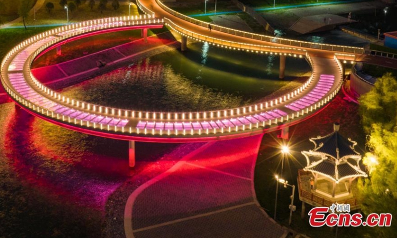 The newly built round glass walkway next to the Nanjing Yangtze River Bridge lights up in Nanjing, east China's Jiangsu Province, April 16, 2022. The colorful round glass walkway looks like a big ring at night. (Photo: China News Service/Yang Bo)