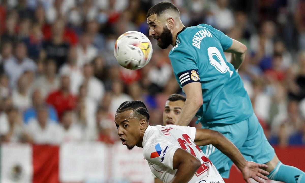 Real Madrid's Karim Benzema (top) heads the ball during the match against Sevilla in Seville, Spain on April 17, 2022. Photo: VCG