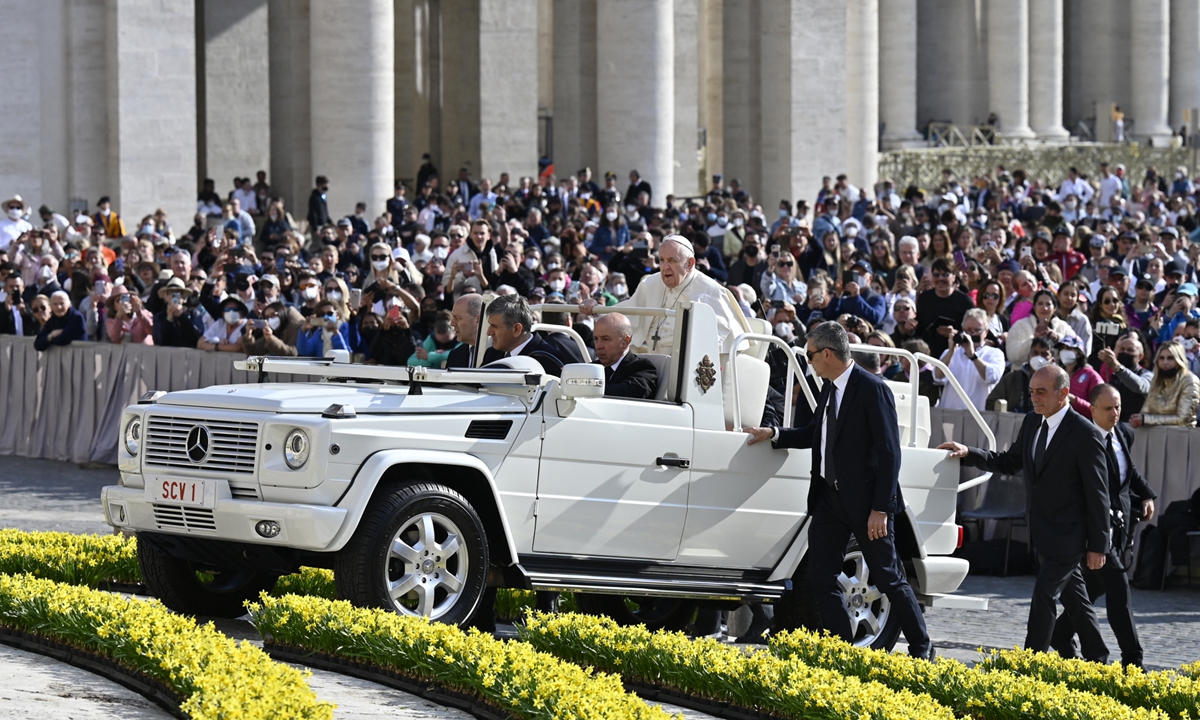 Pope Francis is escorted by his bodyguards as he arrives in the popemobile on April 20, 2022 for the weekly general audience at St. Peter's Square in The Vatican. During the first general audience at the square in over two years, Pope Francis highlights the importance of honoring the elderly, and calls for young people to be educated about life and its stages. Photo: AFP
