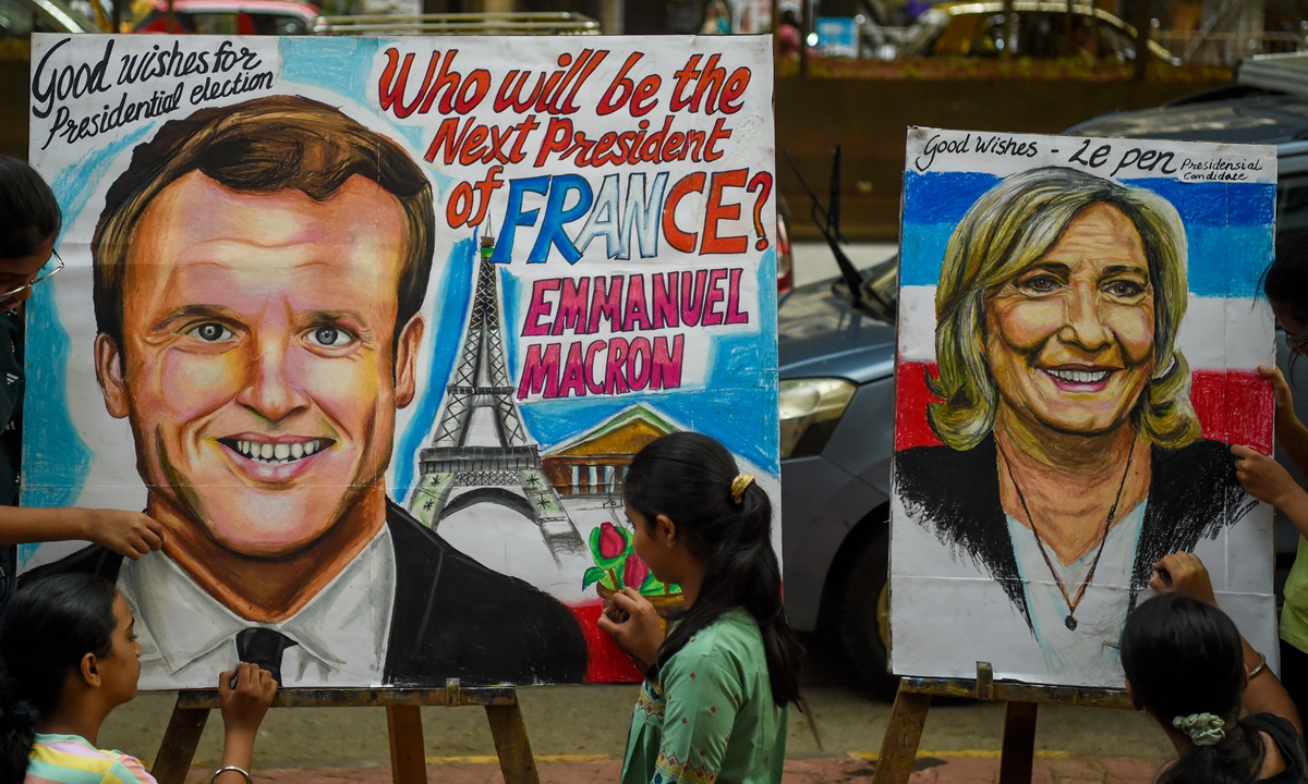 Students pose near paintings of French presidential candidates Emmanuel Macron and Marine Le Pen ahead of the second round of the presidential election, at an art school in Mumbai, India, on April 19, 2022. Photo: AFP