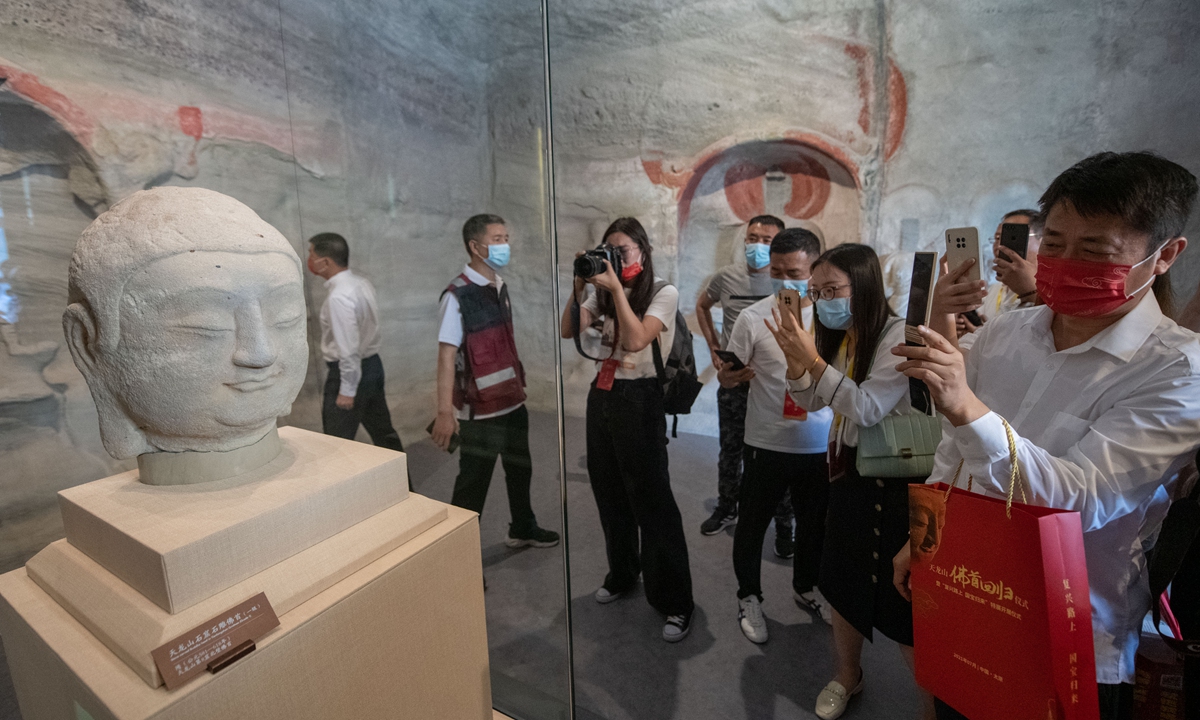 People take photos of the Tianlong Mountain Buddha head repatriated from Japan in Taiyuan, Shanxi Province on July 24, 2021. Photo: VCG 
Right: Renowned Japanese lawyer Keiichiro Ichinose (second right) attends a rally in Tokyo on April 20, 2022. 
Photo: Courtesy of Keiichiro Ichinose