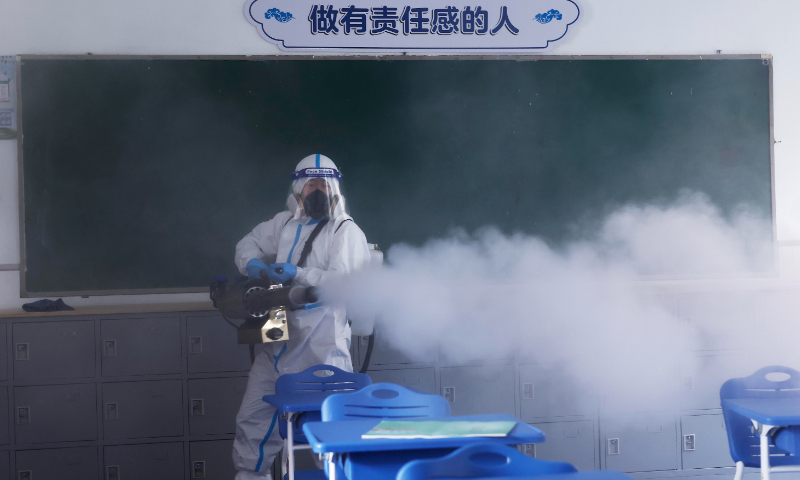 A volunteer disinfects a classroom in a middle school in Pudong New Area, Shanghai on April 21, 2022. Photo: VCG