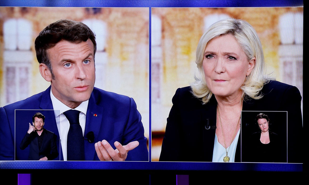 A TV screen displays the debate between Emmanuel Macron and Marine Le Pen.Photo: AFP