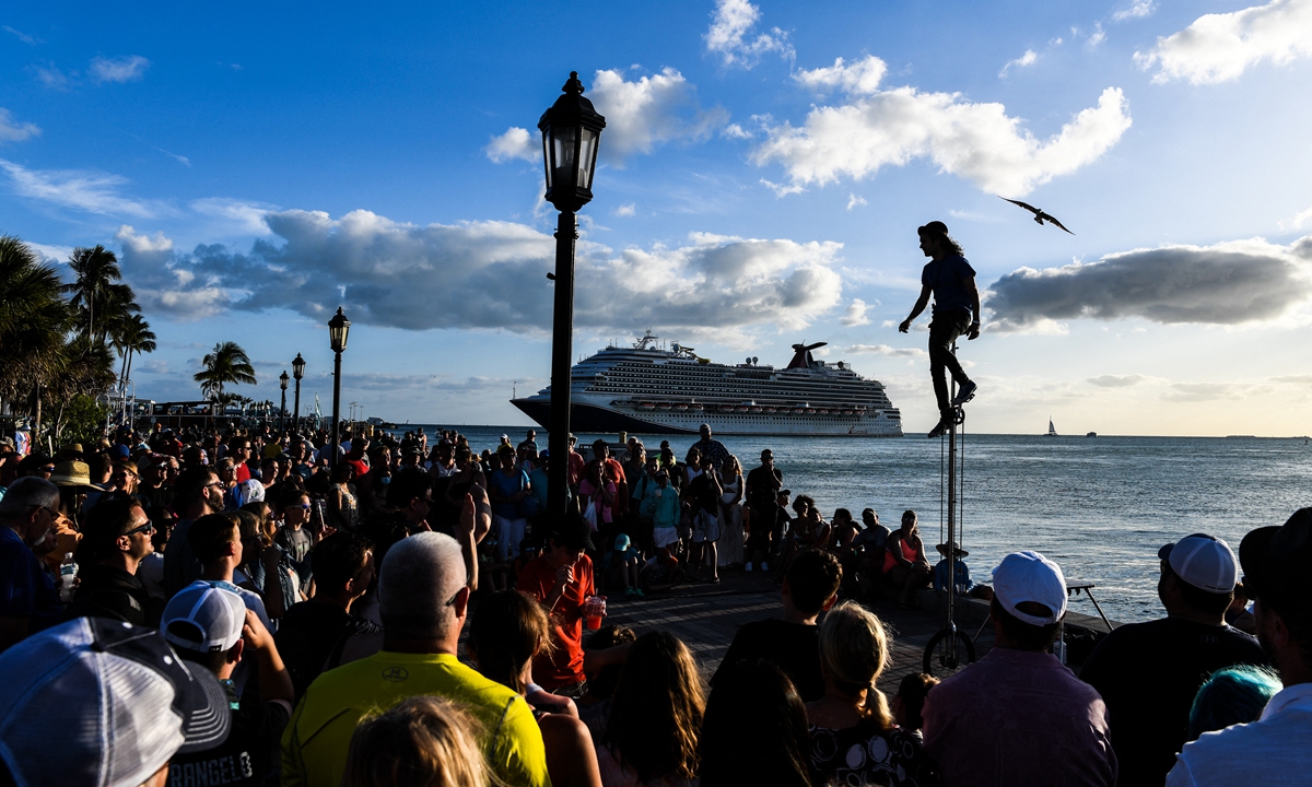People watch an artist perform as the Carnival Dream cruise ship sails in Key West, Florida, on April 11, 2022. Photo: AFP