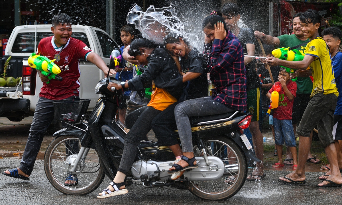 People use water guns to spray water at passing motorists during Cambodian New Year celebrations in Siem Reap province, on April 14, 2022. Photo: VCG 