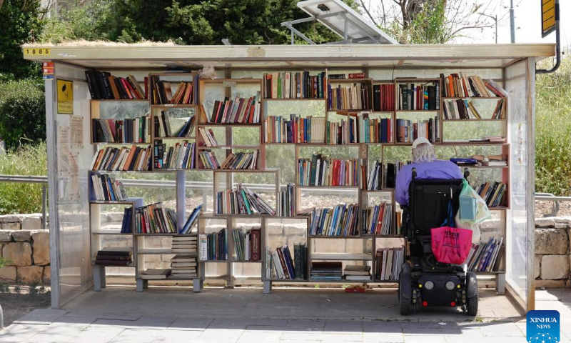 A man reads a book at a street library in Jerusalem ahead of the World Book Day, on April 22, 2022. April 23 marks the World Book Day. (Photo: Xinhua)