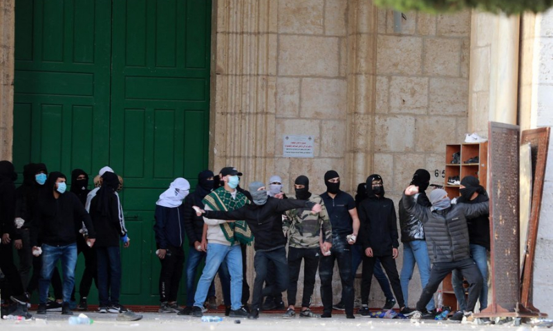 Palestinians hurl stones at Israeli security forces at the Al-Aqsa Mosque compound on April 22, 2022. (Photo: Xinhua)