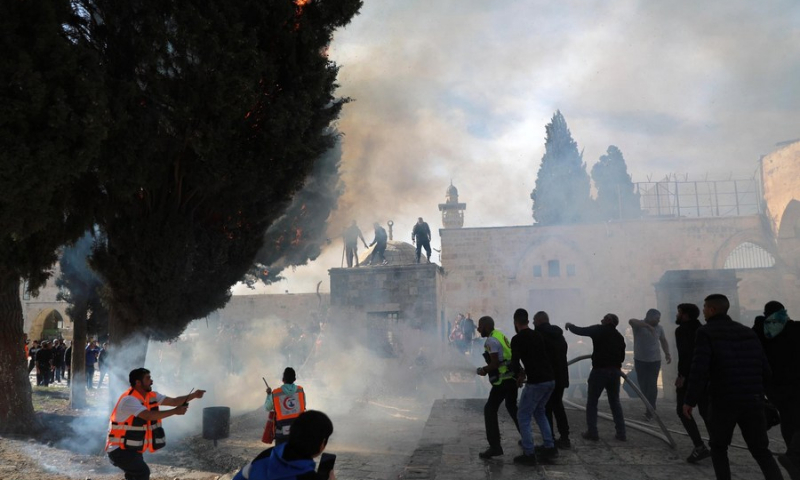 Firefighters douse flames during clashes between Israeli security forces and Palestinians at the Al-Aqsa Mosque compound in East Jerusalem on April 22, 2022. (Photo: Xinhua)