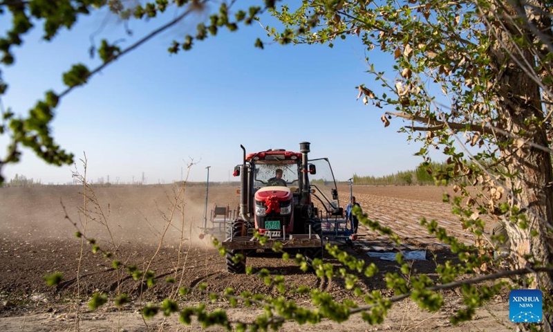 Workers operate a seeder in Ili Mehmet's cotton field in Shawan, northwest China's Xinjiang Uygur Autonomous Region, April 16, 2022. Ili Mehmet, 50, lives in Shawan, a major cotton-producing area in Xinjiang.Photo:Xinhua