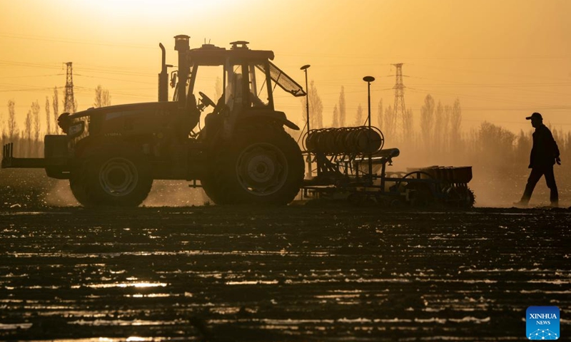 Workers operate a seeder in Ili Mehmet's cotton field in Shawan, northwest China's Xinjiang Uygur Autonomous Region, April 16, 2022. Ili Mehmet, 50, lives in Shawan, a major cotton-producing area in Xinjiang.Photo:Xinhua