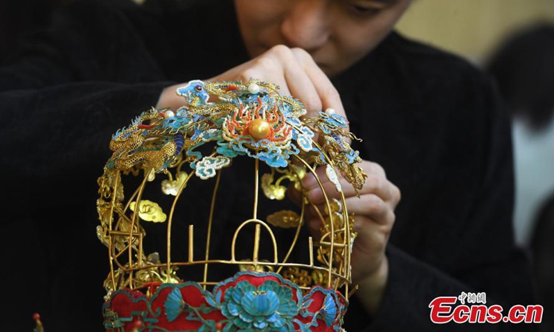 2022年4月21日，重庆，90后青年顾国强用掐丝镶嵌工艺制作饰品。图片来源：新华社