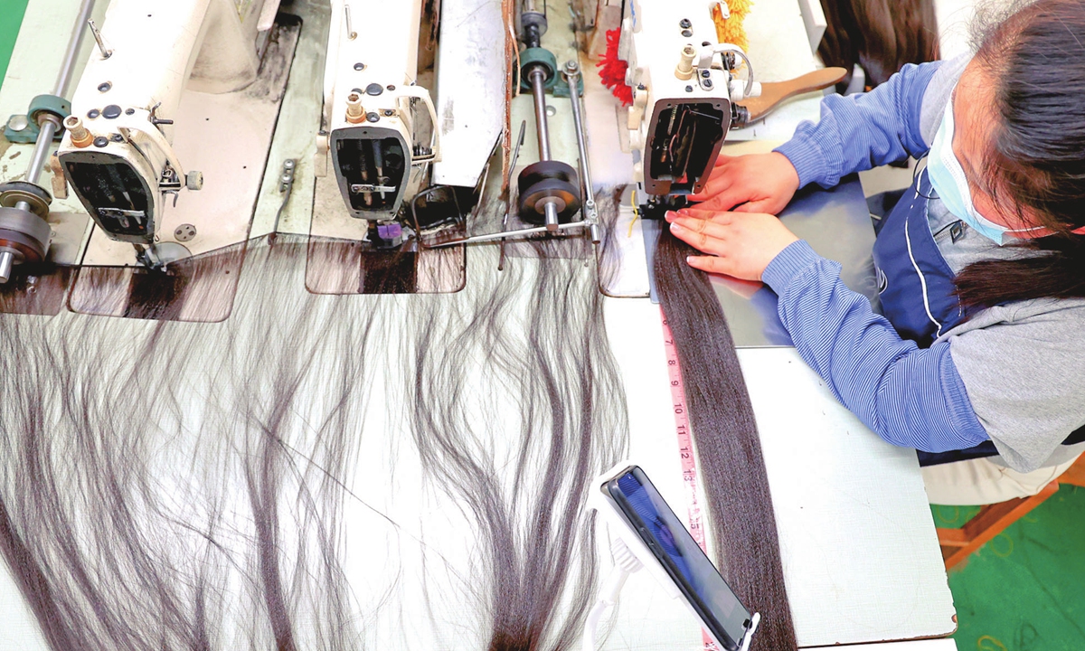 A worker makes wigs at a factory in Lianyungang, East China’s Jiangsu Province on April 24, 2022. Industry data showed that China's wig exports account for more than 70 percent of the global supply. Photo: cnsphoto