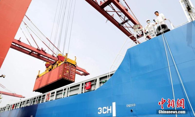 Goods are loaded to Zhi Fei, China's first unmanned autonomous 300TEU container merchant ship, before its maiden voyage in Qingdao, east China's Shandong Province, April 22, 2022. (Photo: China News Service/Zhang Jingang)