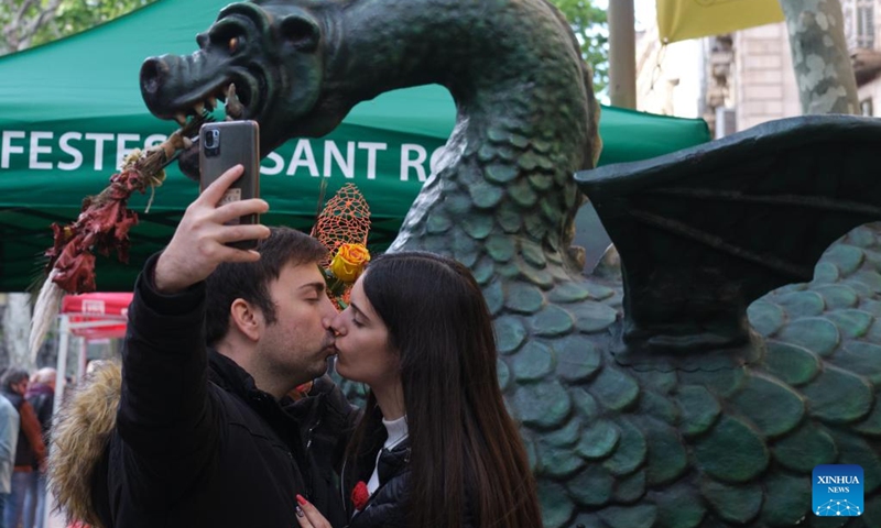 A couple takes selfie in Barcelona, Spain, April 23, 2022. St. George's Day usually sees the streets of Barcelona filled with parades of people exchanging books and flowers with their loved ones. (Xinhua/Meng Dingbo)