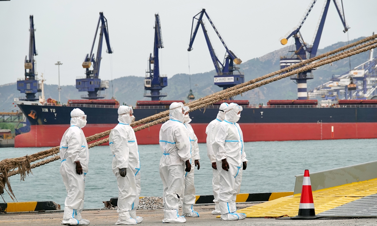 Dockers wear protective clothing at a port in Yantai, East China's Shandong Province, on April 25, 2022. Photo: VCG