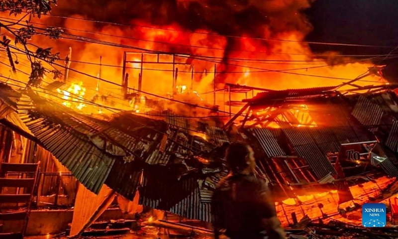 Photo taken with a mobile phone shows firefighters battling a fire in Gembrong Market area in Jakarta, Indonesia, on April 24, 2022.Photo:Xinhua