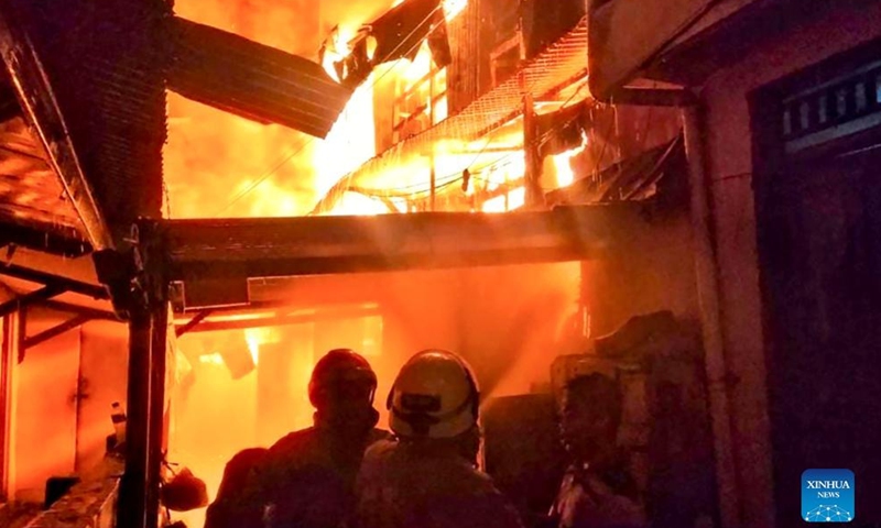 Photo taken with a mobile phone shows firefighters battling a fire in Gembrong Market area in Jakarta, Indonesia, on April 24, 2022.Photo:Xinhua