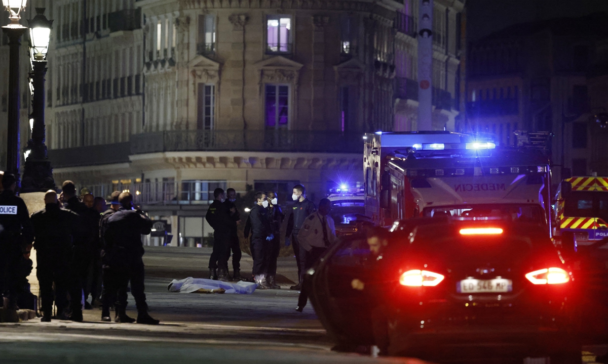 Police officers investigate the body of one of two people shot by police in Paris on April 25, 2022. Shortly after midnight on April 24, 2022, police opened fire on a car that refused to stop at a police checkpoint on the Pont Neuf in Paris. Police told AFP the car was driving against traffic and sped toward officers, who were forced to open fire, according to the same police source. Photo: AFP