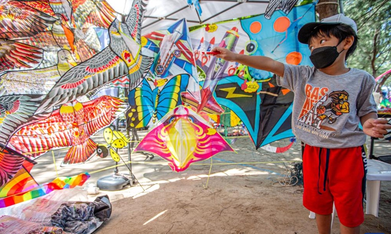A child selects kites at the Cha-am Beach in Phetchaburi, Thailand, on April 23, 2022.Photo:Xinhua