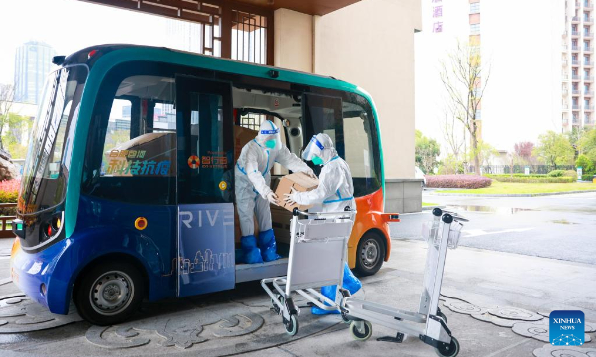 Staff member unload supplies from an unmanned delivery vehicle at a hotel for COVID-19 quarantine in Hefei, east China's Anhui Province, March 22, 2022. Photo:Xinhua
