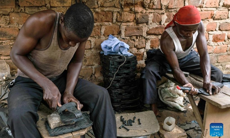 Men assemble rubber sandals made out of worn-out tires at Makerere Kivulu in Kampala, Uganda, March 7, 2022.(Photo: Xinhua)