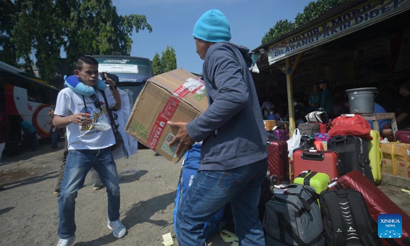People carry their belongings at a bus station during Eid al-Fitr festival in Jakarta, Indonesia, April 25, 2022. The holy month of Ramadan and the celebration of Islamic post-fasting festivity Eid-al-Fitr have been associated with a homecoming tradition locally known as mudik for most of the Indonesian people.(Photo: Xinhua)