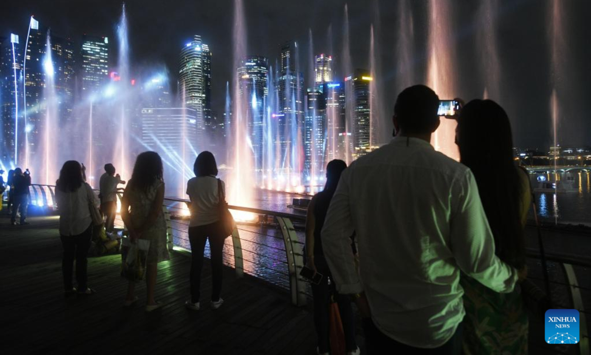 Tourists view the Spectra light and water show, returning after a 2-year hiatus due to the COVID-19 countermeasures, held at Singapore's Marina Bay Sands on April 28, 2022. Photo:Xinhua