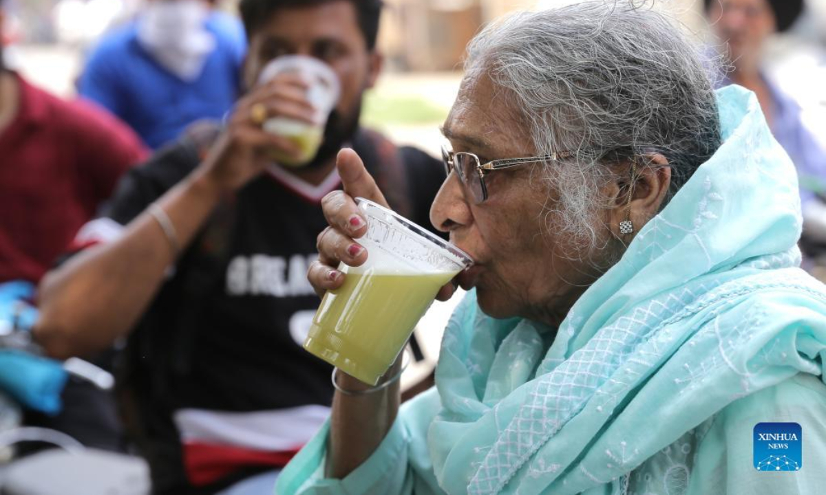 People drink cold sugarcane juice at the roadside during a heat wave in Amritsar, Punjab state, northern India, on April 29, 2022. A heat wave has gripped entire northern India, including Delhi, Rajasthan, Uttar Pradesh, Haryana, Himachal Pradesh and Punjab. Photo:Xinhua