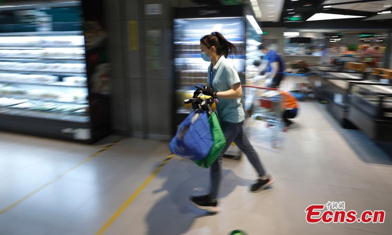 2022年4月26日，北京朝阳区盒马生鲜店，工作人员正在准备网上订购的商品。（图片：中新社/福田）
