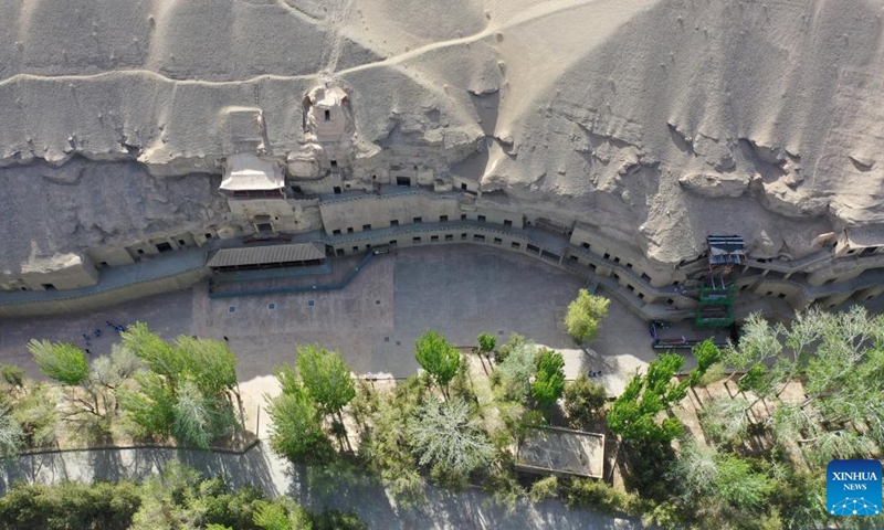 Aerial photo taken on April 19, 2022 shows the Mogao Grottoes in Dunhuang, northwest China's Gansu Province. Located in Dunhuang, northwest China's Gansu Province, the millennium-old Mogao Grottoes are home to a vast collection of Buddhist artworks which are considered the finest in existence -- more than 2,000 colored sculptures and 45,000 square meters of murals -- in 735 caves carved along a cliff by ancient worshippers.(Photo: Xinhua)