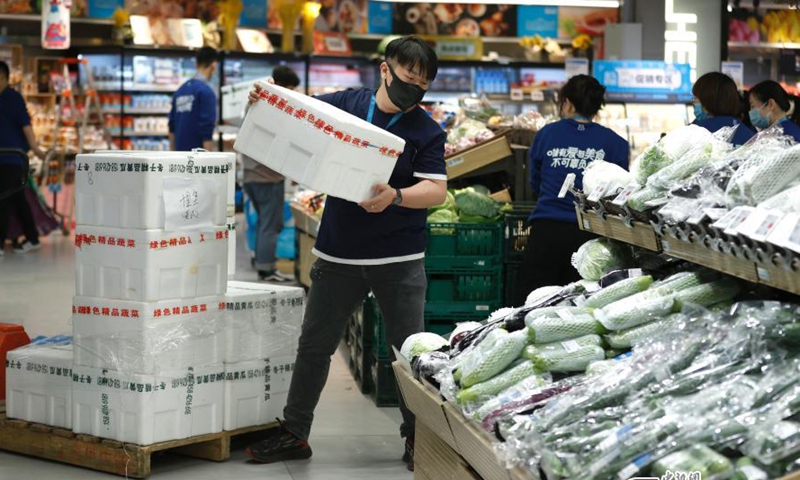 2022年4月26日，工作人员在北京朝阳区盒马生鲜店卸菜。（图片：中新社/福田）