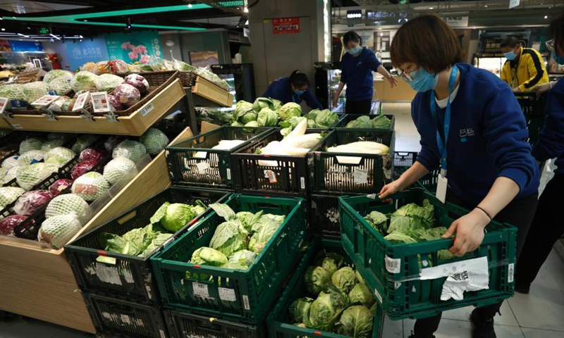 A staff member stacks vegetables at a Hema Fresh store in Chaoyang District, Beijing, April 26, 2022. (Photo: China News Service/Fu Tian)